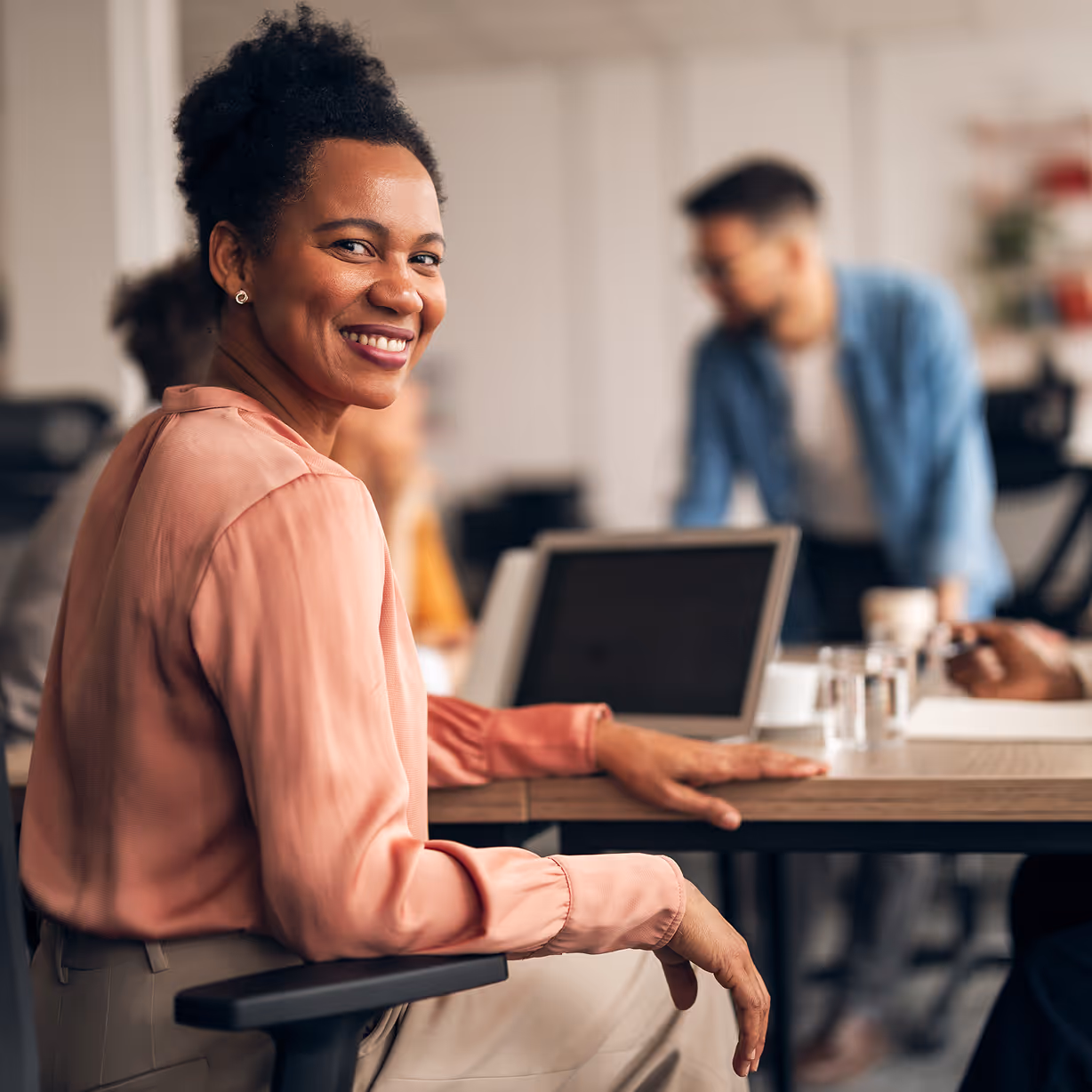 Smiling Professional Woman During Collaborative Office Meeting with Colleagues