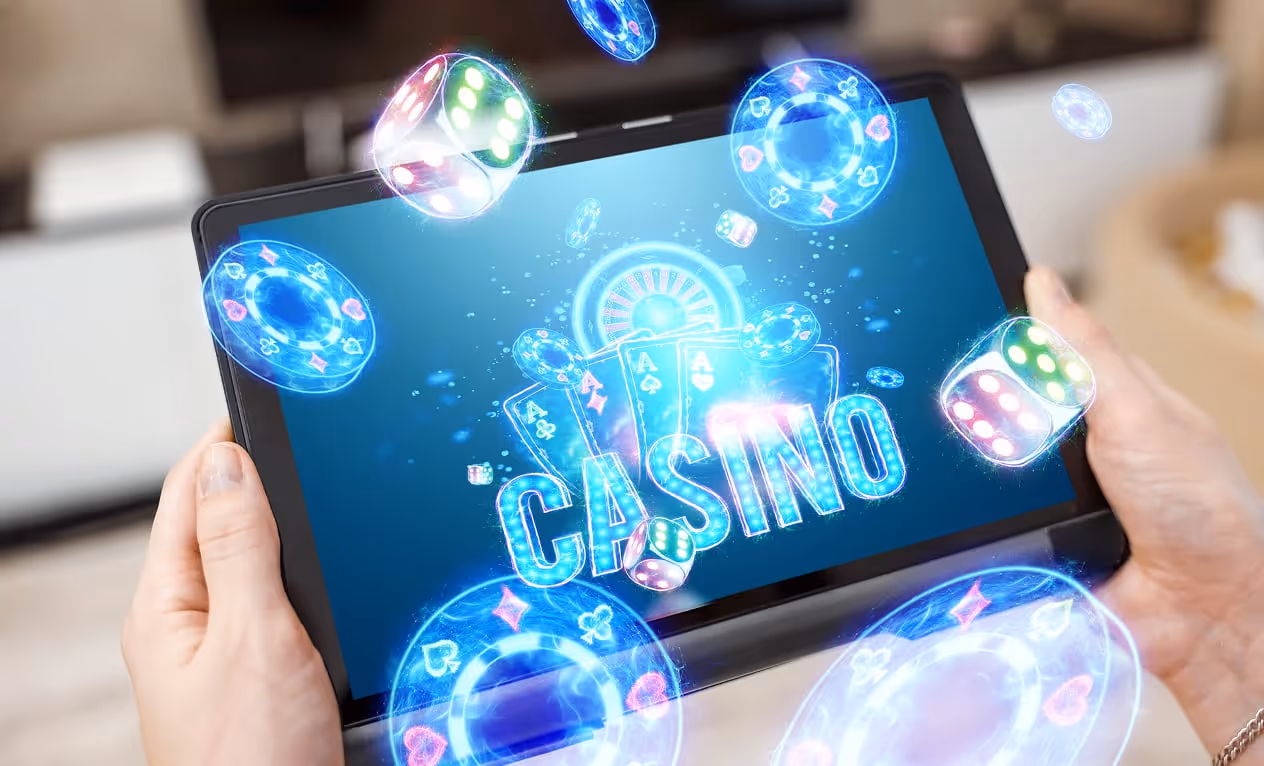 A tablet in female hands and neon casino reboot, roulette, dice, chips. Online casino, gambling, iGaming, betting.